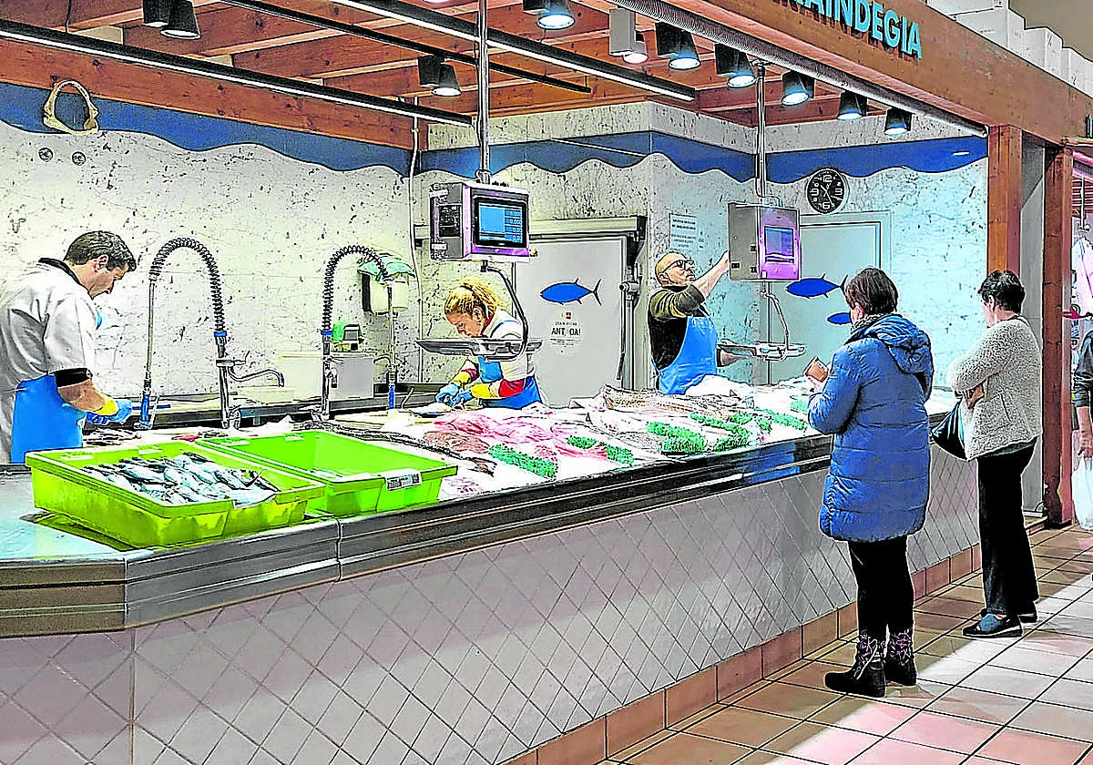 Varios clientes esperan su turno para comprar en uno de los dos puestos de la pescadería del mercado de abastos de Algorta.