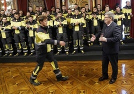 El alcalde entrega su insignia a uno de los 56 bomberos que han pasado a ser funcionarios.