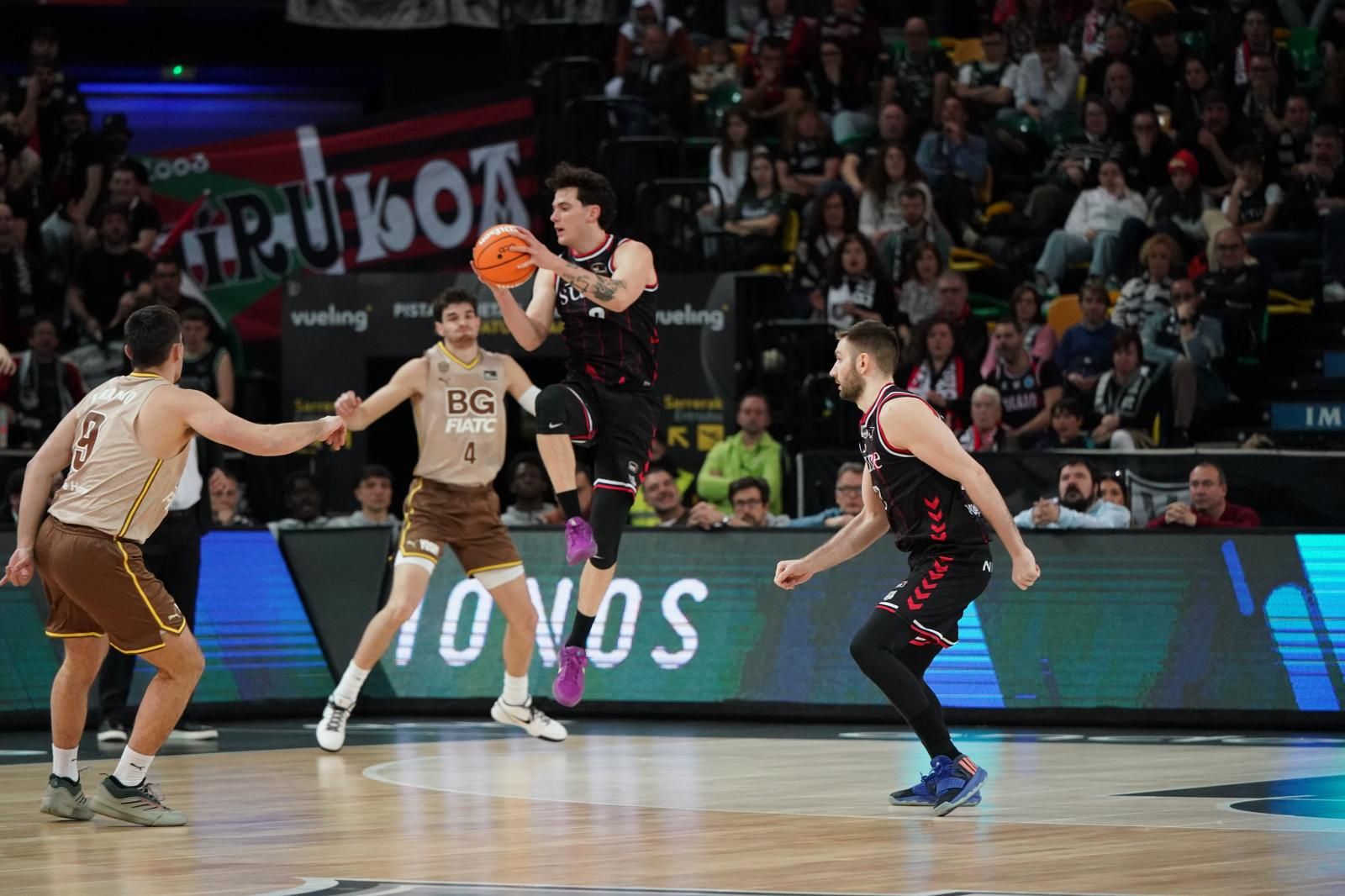 Domínguez coge el balón en el aire ante la mirada de su compañero Kristian Kullamae.