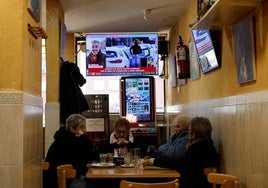 Un grupo de mujeres toma unas consumiciones en un bar con la televisión puesta.