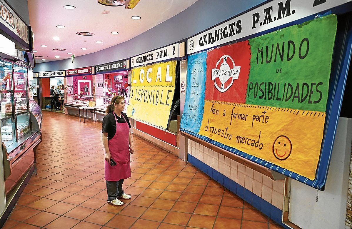 Una comerciante del mercado de Otxarkoaga, frente a un establecimiento vacío.