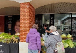 Dos vecina de Sopela compran verduras en uno de los puestos del mercado local.