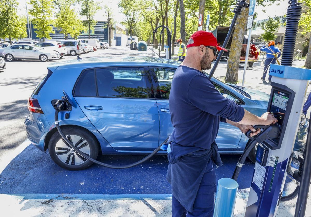 Un conductor carga la batería de su turismo en un poste de Zunder situado en el aparcamiento de Mendizorroza.