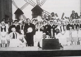 Integrantes del Orfeón sobre el escenario en una representación de 1927, ante el decorado de la obra 'Molinos de Viento'.