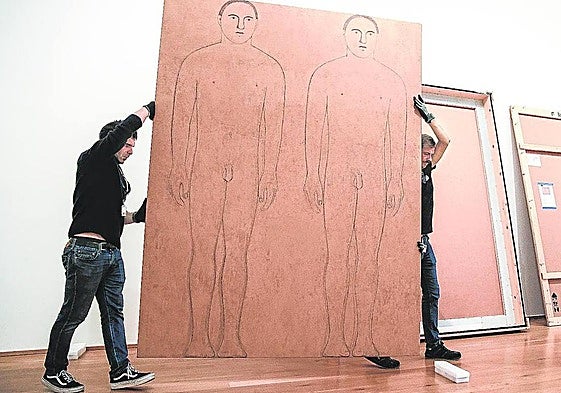 Trabajadores trasladan una obra de arte.