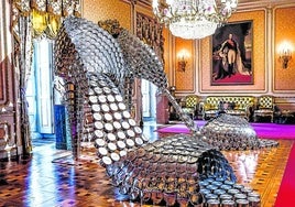 Los gigantescos 'stilettos' de Marilyn, confeccionados con ollas caseras, deslumbran bajo la araña de cristal de uno de los salones del palacio.