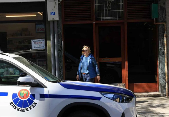 Un vehículo de la Ertzaintza frente al portal donde residía el fallecido hallado axfisiado en Irun.