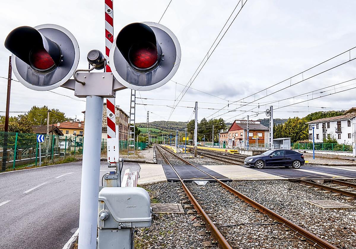 Un coche atraviesa las vías en el paso a nivel en Manzanos.