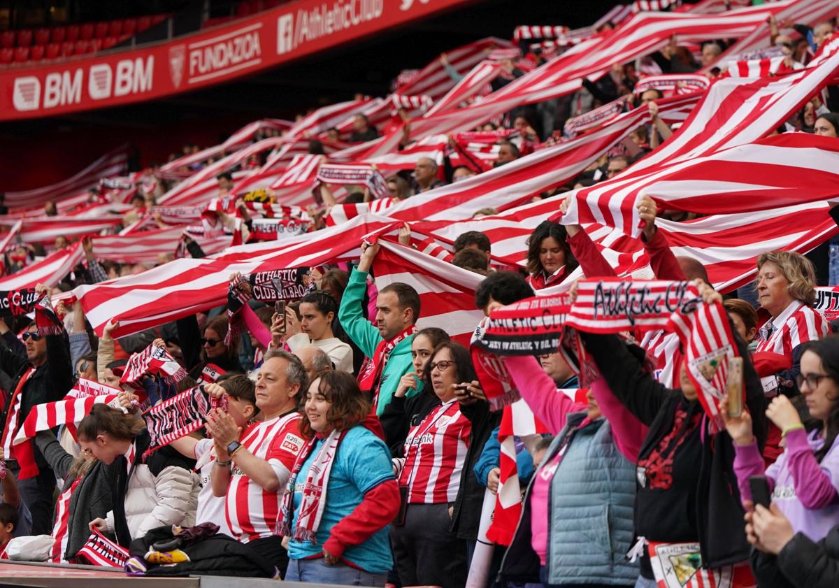 Imagen principal - Arriba, una parte de los más de 10.000 espectadores despliega el tifo mostrado antes del pitido inicial. A la izquierda, la ofrenda floral de Mari Jose, capitana de un Tenerife que se estrenó en San Mamés. A la derecha, Oguiza recibe las felicitaciones de sus compañeras tras anotar el primer gol.