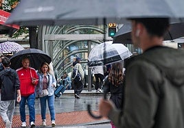 Peatones con paraguas en el entorno de Moyua, esta tarde.