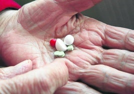 Una mujer mayor revisa varias pastillas.