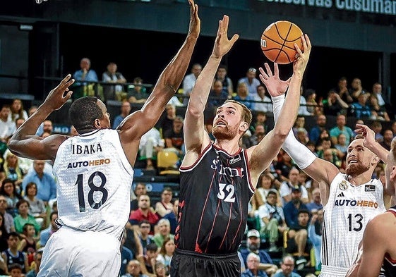 Hlinason alarga sus enormes brazos para buscar el aro ante un experto taponador como el madridista Ibaka.