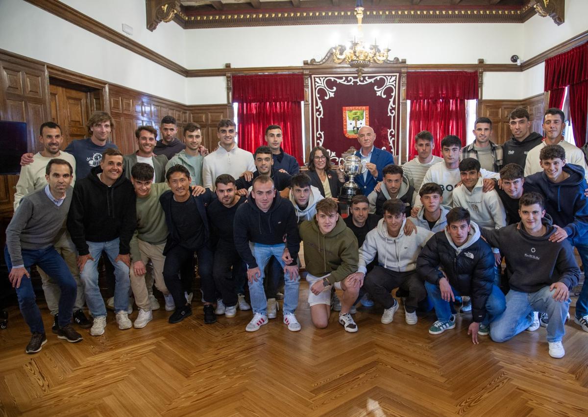 Imagen secundaria 1 - Arriba, Ibai Gómez, entrenador del Arenas conversa con Amaia Agirre. A la izquierda, foto de familia dentro del Salón de Plenos. A la derecha, la directiva posa con el trofeo de campeón de Segunda Federación.