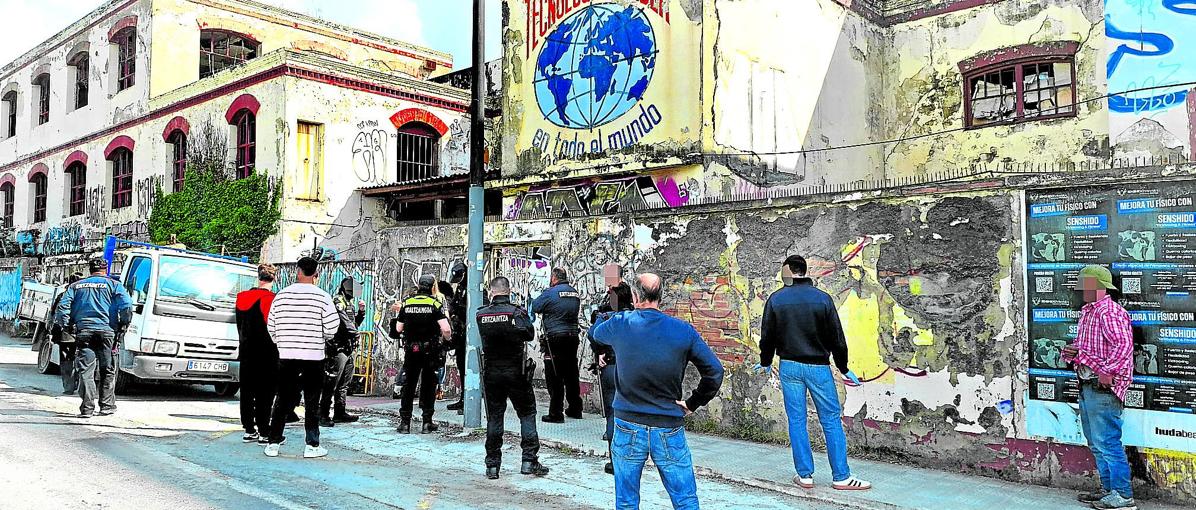 Agentes de la Policía Local y la Ertzaintza esperan a que salgan los ocupantes después de haberlos identificado.