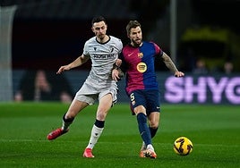 Iñigo Martínez choca con el osasunista Raúl Gracia.