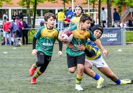Un niño trata de placar a otro en un partido de la Araba Rugby Cup.