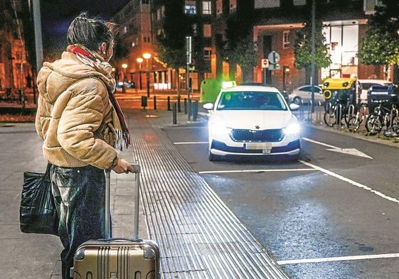 Una vitoriana espera a un taxi en una parada.