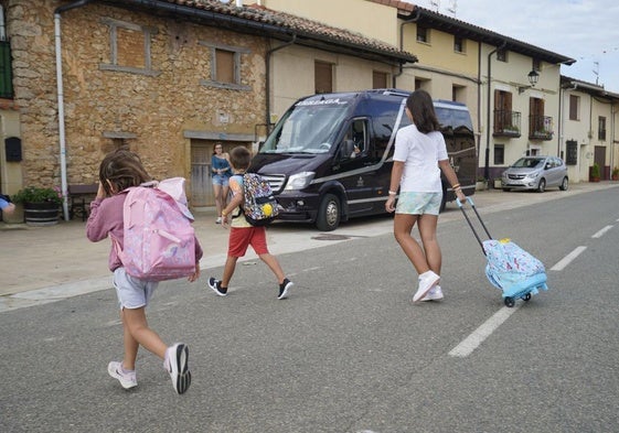 Unos niños de Lagrán se dirigen al microbús que les lleva al colegio en Campezo.