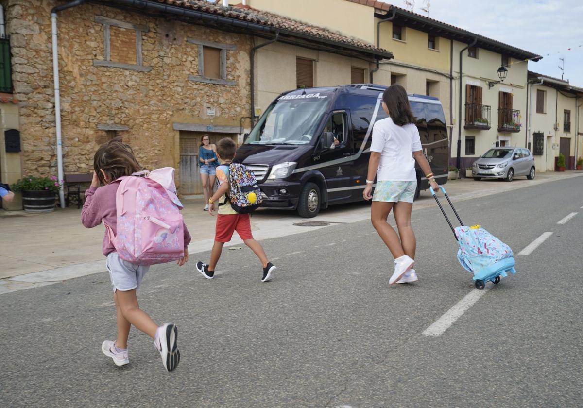 Unos niños de Lagrán se dirigen al microbús que les lleva al colegio en Campezo.