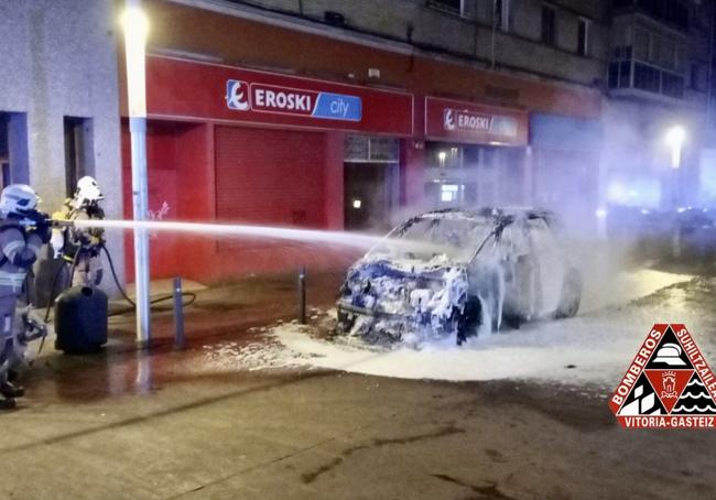 Los bomberos sofocan las llamas que calcinaron el coche.