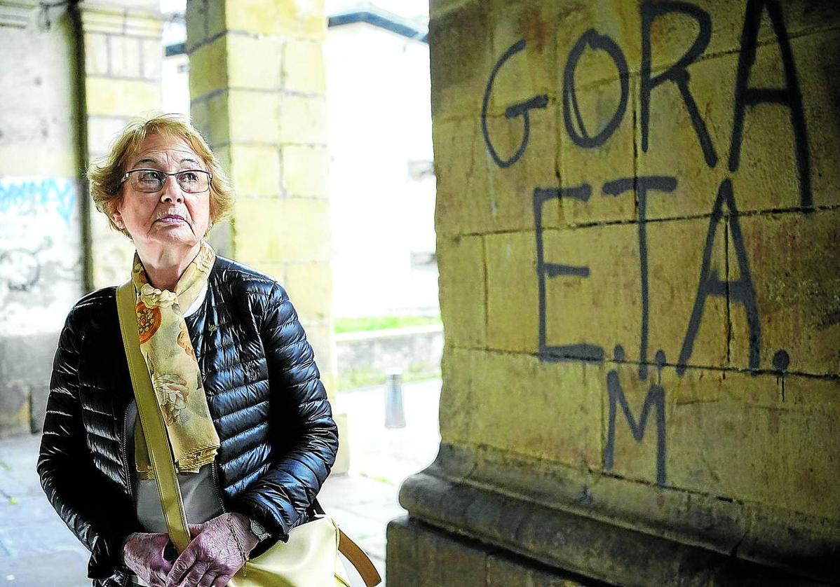 Carmen Hernández, viuda de Jesús Mari Pedrosa, retratada esta semana en los soportales de la iglesia de Santa Ana en Durango, junto a una pintada de apoyo a ETA.