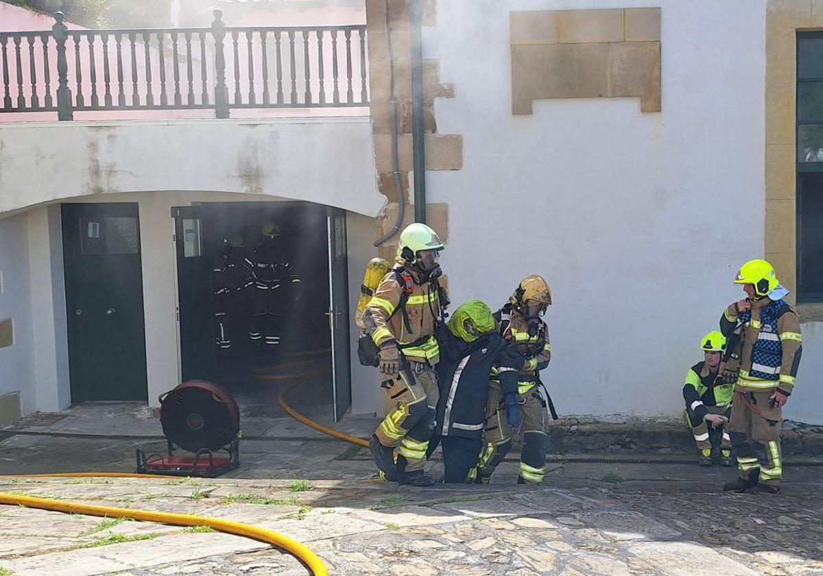 Dotaciones de bomberos simulan el rescate de una persona tras un incendio en un edificio del Puerto Viejo.