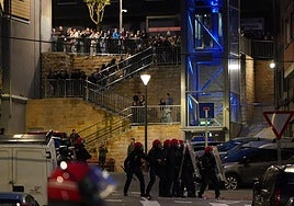 Jovenes encapuchados se enfrentan a agentes de la Ertzaintza durante el desalojo del gaztetxe de Rekalde.