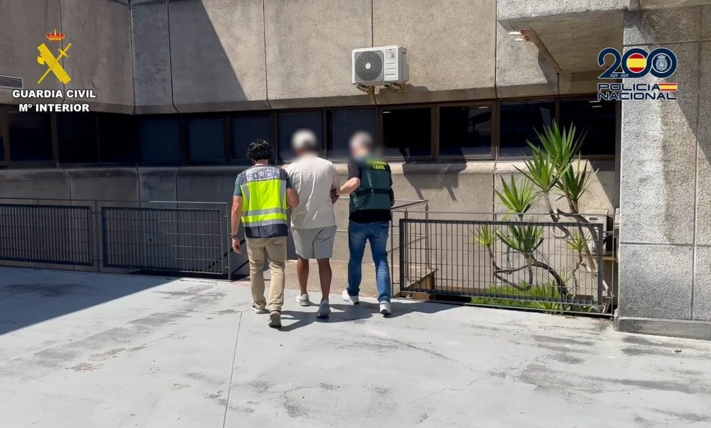 Agentes de la Guardia Civil y la Policía Nacional escoltan a un detenido a comisaría.
