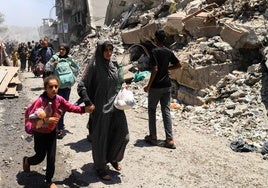 Palestinos evacuados tras un ataque israelí contra una casa en la ciudad de Gaza.