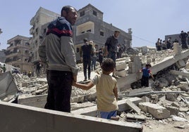 Un padre y su hijo, ante los escombros de casas destruidas en Jabalia.