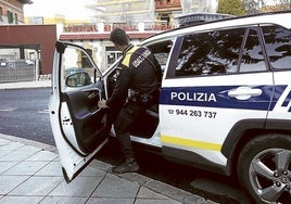 Un agente de la Policía Municipal de Etxebarri accede al coche patrulla.