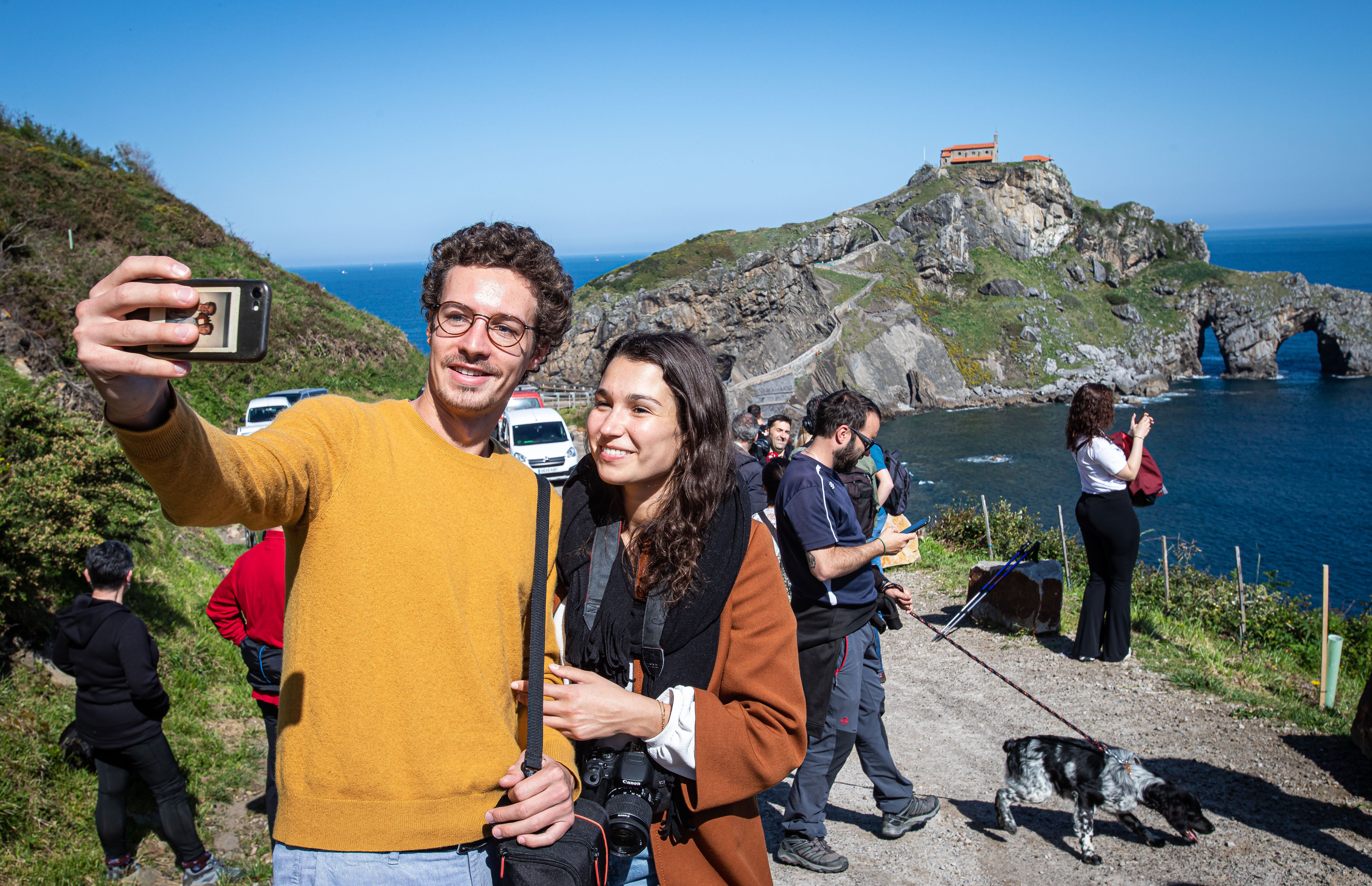 Dos turistas inmortalizan en una foto su visita a San Juan de Gaztelugatxe.
