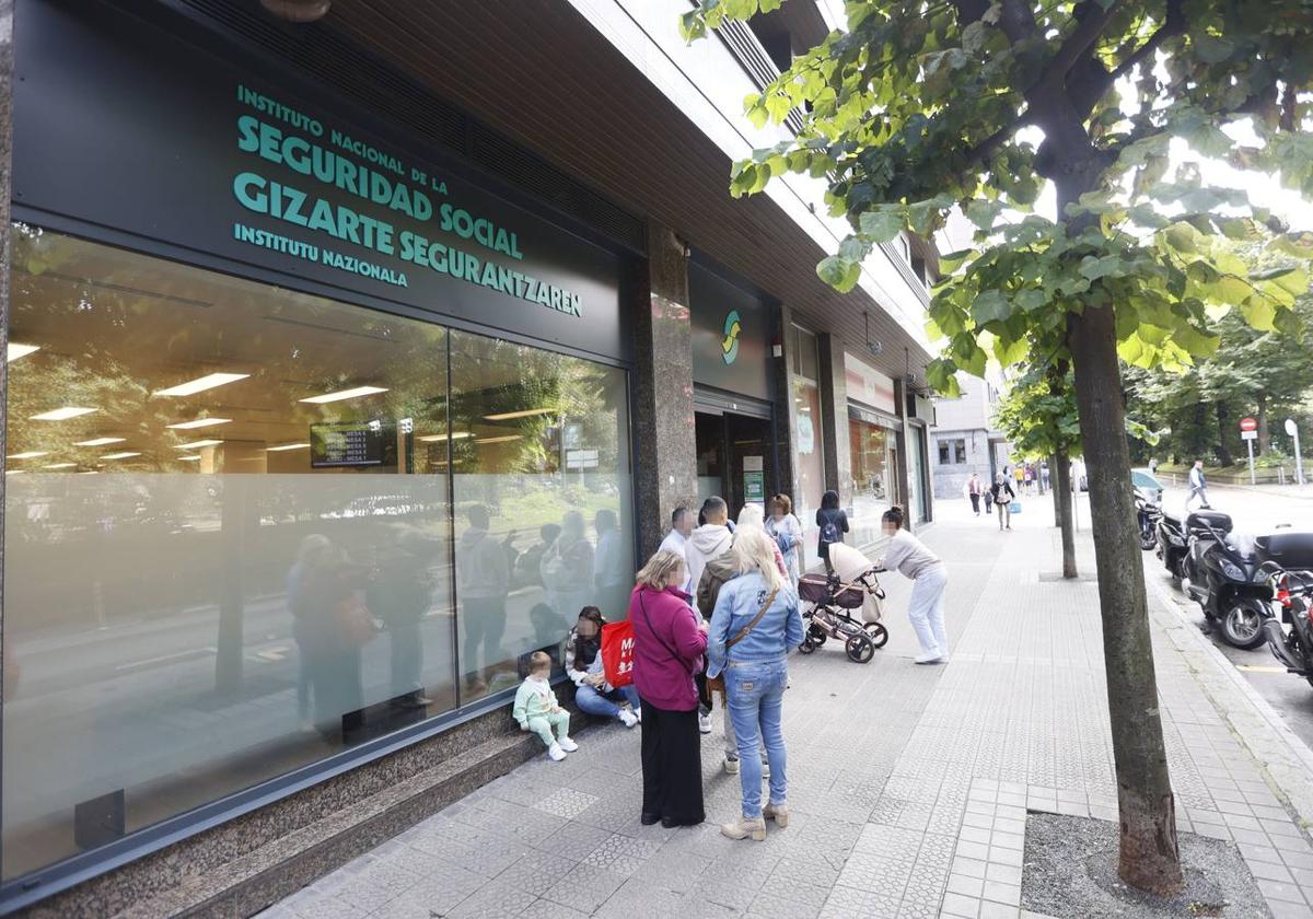 Gente haciendo cola ante las oficinas de la Seguridad Social.