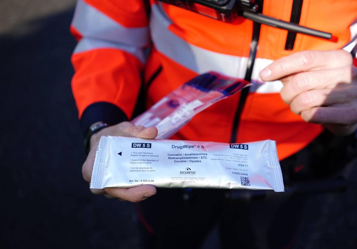 Imagen de un ertzaina con uno de los test de drogas que se usan en los controles.