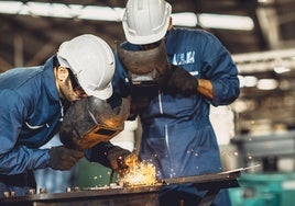Dos operarios trabajan en una empresa del sector industrial.