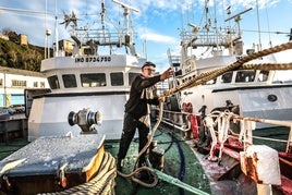 Un marinero lanza la maroma para amarrar el pesquero en el puerto de Ondarroa.