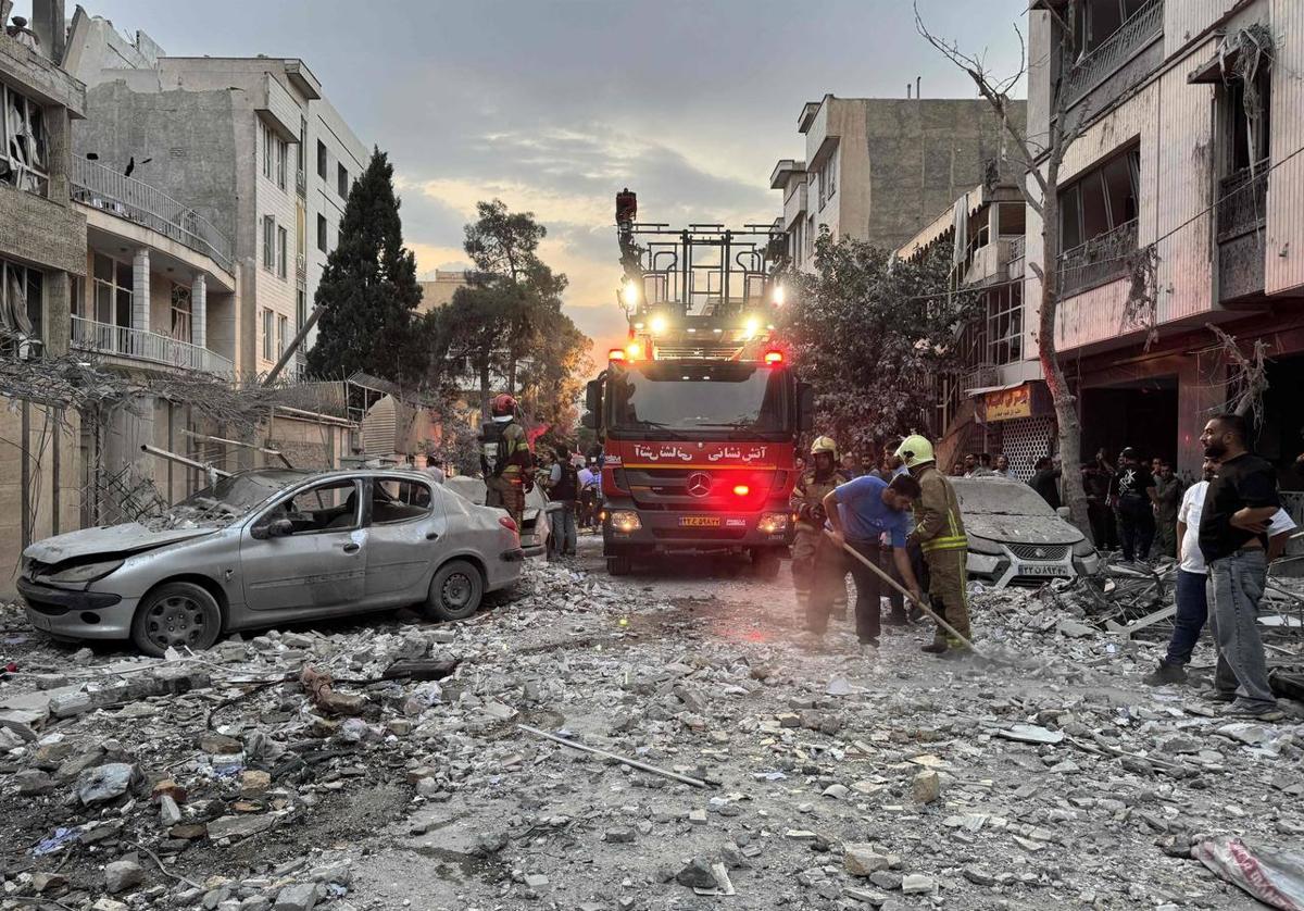 Bomberos trabajan en un edificio alcanzado tras el ataque israelí en Teherán.