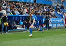 Toni Martínez corre por el balón ante la mirada de Coudet.