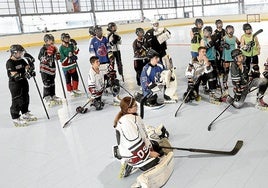 Jugadores de las categorías inferiores del Metropolitano HCatienden a un entrenador en la pista del polideportivo municipal de Zorroza.