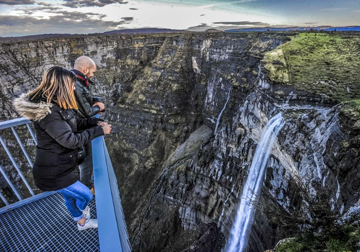 Dos visitantes se asoman al mirador sobre el Salto del Nervión.