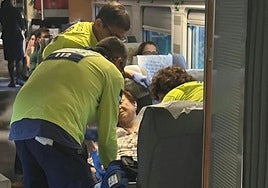 Momento en el que los servicios de Emergencias atienden a una viajera dentro del tren parado.