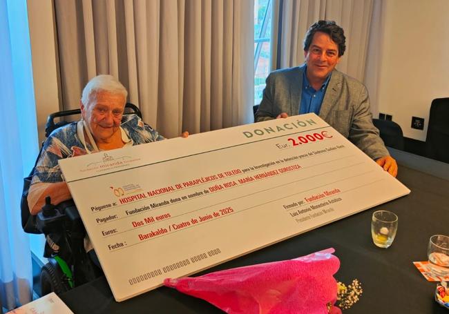 Rosa haciendo entrega del cheque para la investigación de su enfermedad.