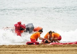 Los socorristas que han participado en el ejercicio atienden al bañista rescatado.