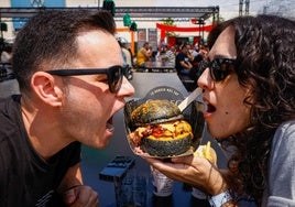 Una pareja se dispone a hincarle el diente a su hamburguesa.