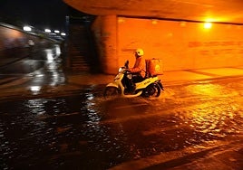 Una moto pasa por inundado túnel de San Antonio.