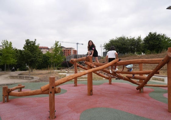 Unos niños juegan a hacer equilibrios sobre unos troncos