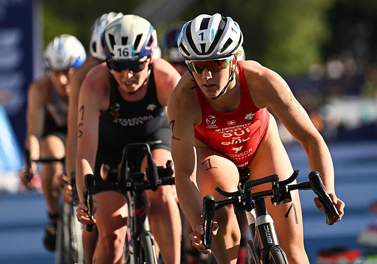 Derron rueda con su bicicleta por delante de Non Stanford en el triatlón de Múnich de 2022.