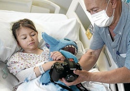 La pequeña Leire en su cama del hospital de Cruces junto a su abuelo.