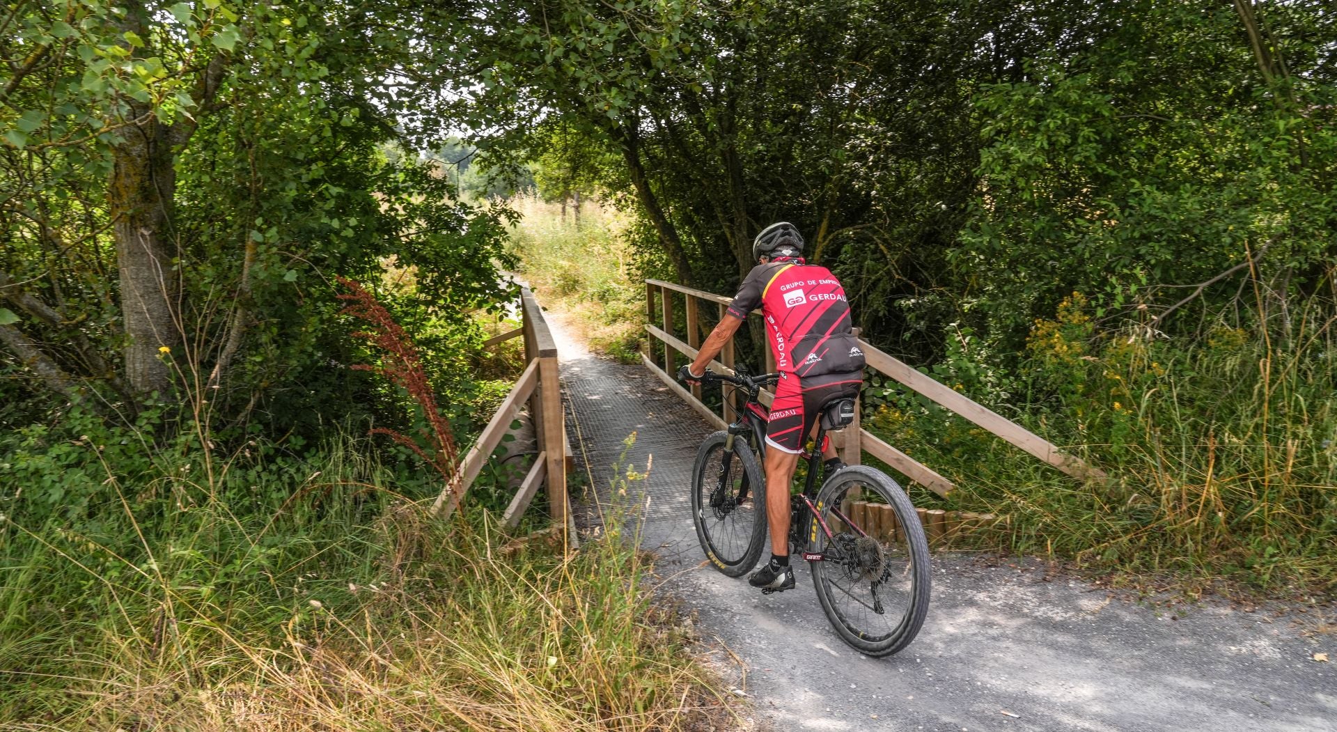 Un ciclista antes de pasar por uno de los puentecillos del nuevo corredor verde al oeste del Anillo Verde.