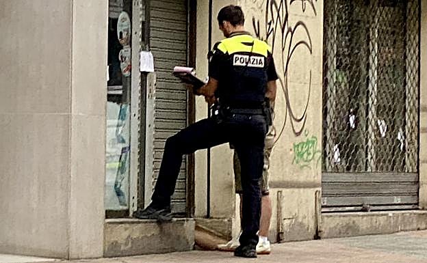 El comerciante sospechoso firma el acta redactada por el patrullero de la Policía Local.
